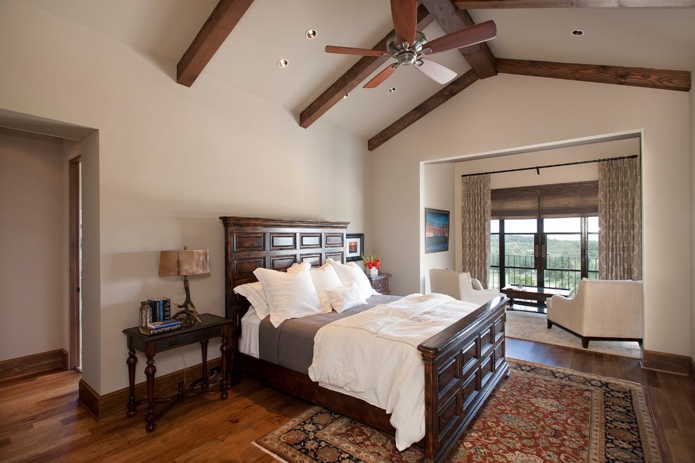 This is an example of a mid-sized contemporary master bedroom in Austin with beige walls, medium hardwood floors and no fireplace.