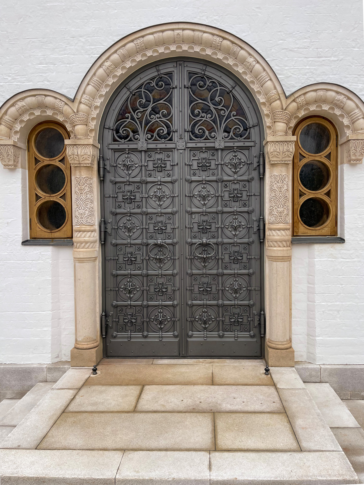 Кованые двери в Храм с витражными окнами.