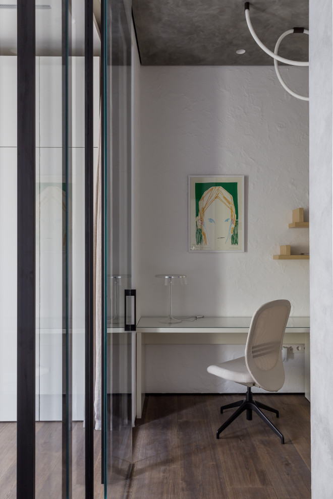 Стильный дизайн: кабинет в современном стиле с белыми стенами, деревянным полом и встроенным рабочим столом - последний тренд