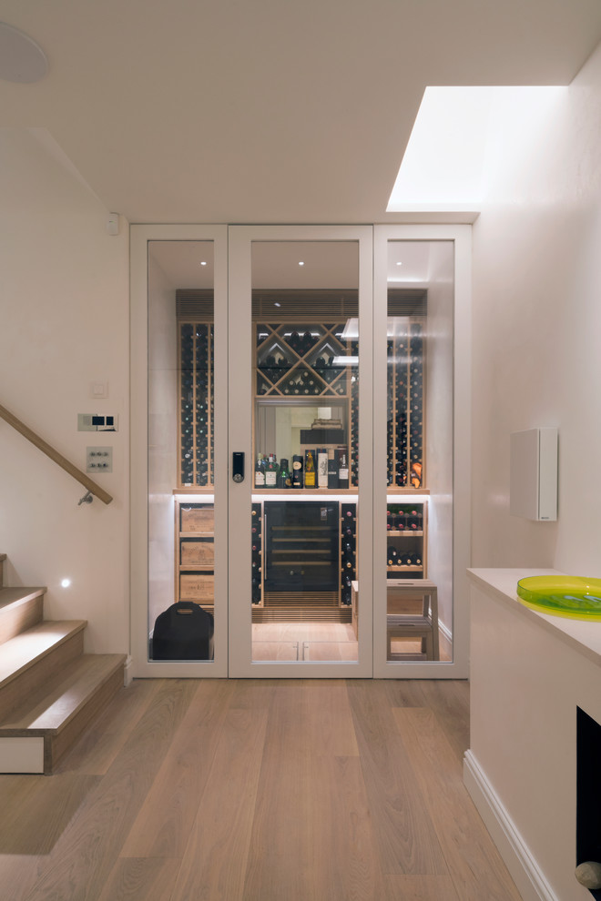 This is an example of a mid-sized contemporary wine cellar in London.
