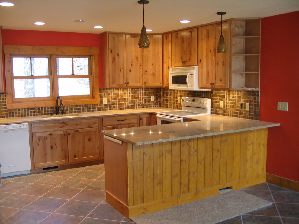 Enclosed kitchen - mid-sized rustic u-shaped porcelain tile and beige floor enclosed kitchen idea in Minneapolis with an undermount sink, recessed-panel cabinets, light wood cabinets, quartz countertops, beige backsplash, porcelain backsplash, white appliances and a peninsula