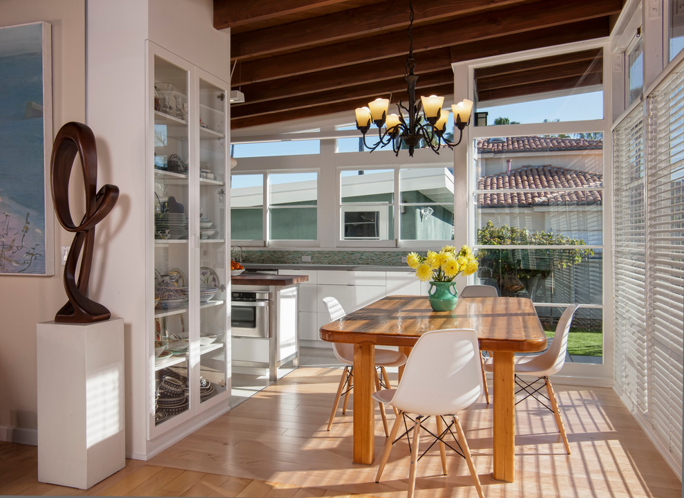 Photo of a midcentury dining room in San Diego with white walls and light hardwood floors.