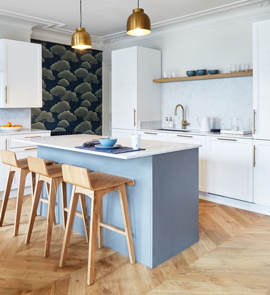 Mid-sized contemporary l-shaped kitchen in Paris with an undermount sink, shaker cabinets, white cabinets, grey splashback, panelled appliances, light hardwood floors, with island, beige floor and white benchtop.