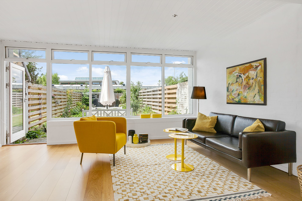 Example of a mid-sized danish formal and open concept light wood floor living room design with white walls and no tv