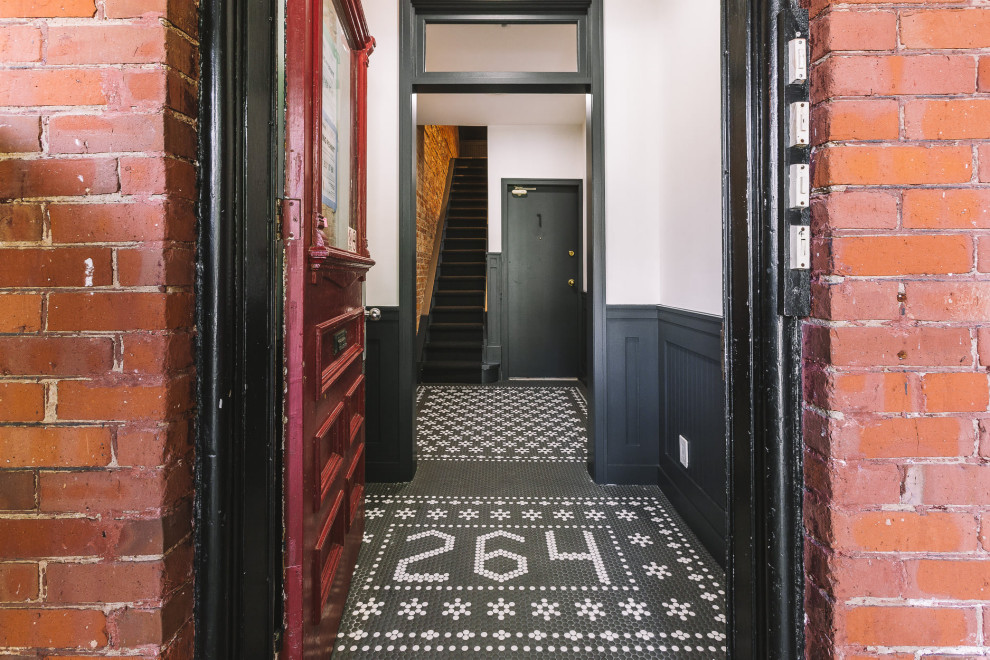 Источник вдохновения для домашнего уюта: фойе в стиле модернизм с полом из керамогранита, одностворчатой входной дверью, красной входной дверью, черным полом и панелями на стенах