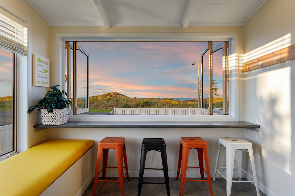 Idee per una sala da pranzo aperta verso il soggiorno stile marino con pareti beige, pavimento in linoleum, pavimento grigio e soffitto a volta