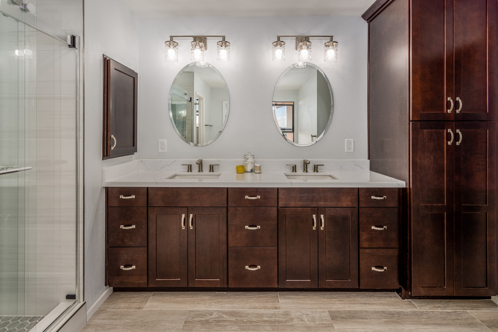 Design ideas for a medium sized traditional ensuite bathroom in San Diego with recessed-panel cabinets, dark wood cabinets, an alcove shower, beige tiles, porcelain tiles, beige walls, porcelain flooring, a submerged sink, engineered stone worktops, beige floors, a sliding door, white worktops, a shower bench, double sinks and a built in vanity unit.