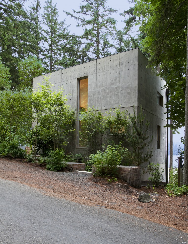 This is an example of a mid-sized contemporary three-storey concrete grey house exterior in Seattle with a flat roof.