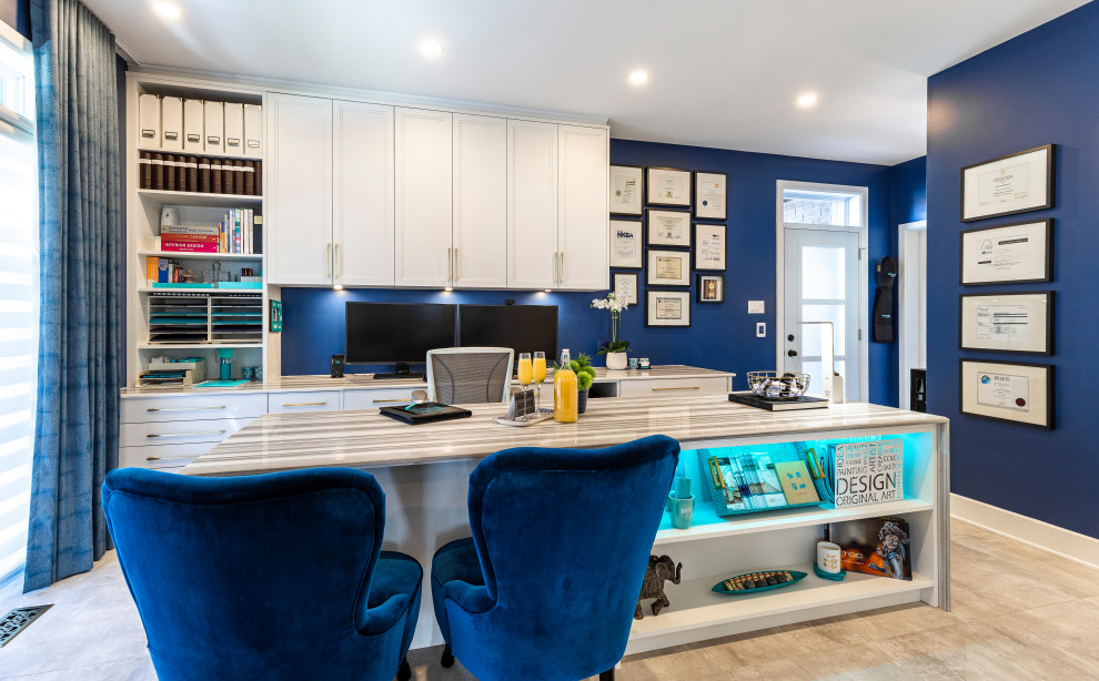 Modern inredning av ett mycket stort hemmastudio, med blå väggar, klinkergolv i porslin, ett inbyggt skrivbord och grått golv