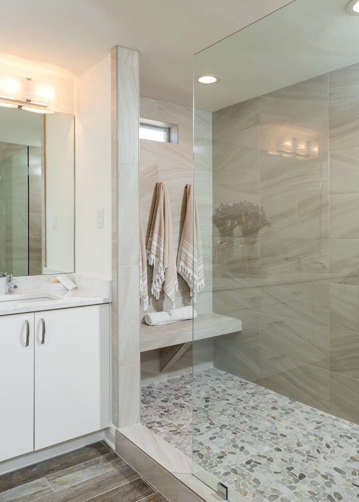 Photo of a large beach style master bathroom in Other with white walls, porcelain floors, flat-panel cabinets, white cabinets, an open shower, a two-piece toilet, multi-coloured tile, porcelain tile, an undermount sink, engineered quartz benchtops, brown floor and an open shower.