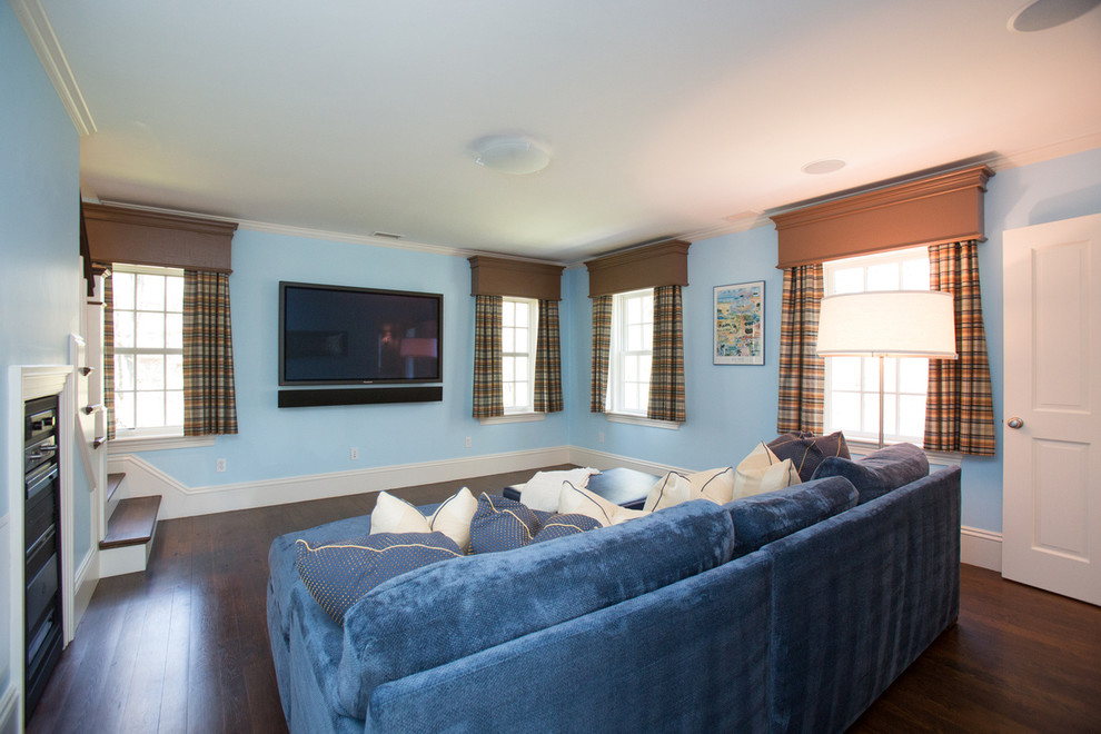 Traditional family room in Boston with blue walls, dark hardwood floors and a built-in media wall.