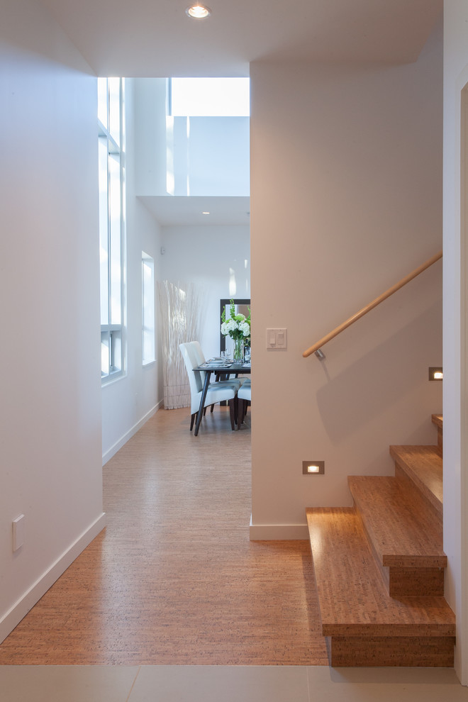 This is an example of a contemporary hallway in Vancouver with white walls and cork floors.