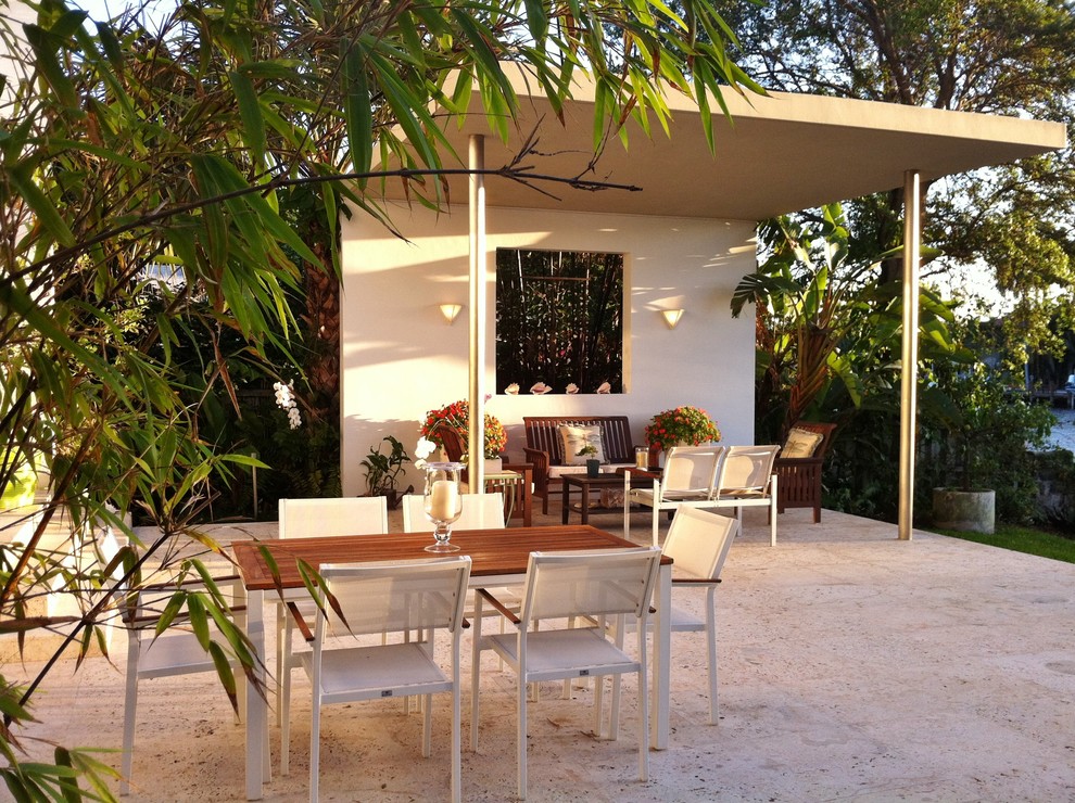 This is an example of a modern patio in Miami with a roof extension.