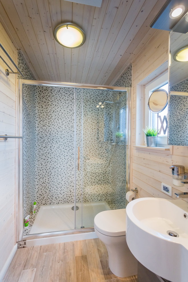 Maritimes Duschbad mit flächenbündigen Schrankfronten, grauen Schränken, grauen Fliesen, weißer Wandfarbe, Vinylboden, Einbauwaschbecken, braunem Boden und Schiebetür-Duschabtrennung in Hamburg