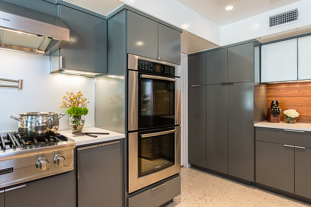 Mid-sized contemporary u-shaped eat-in kitchen in Austin with a farmhouse sink, flat-panel cabinets, grey cabinets, quartz benchtops, white splashback, timber splashback, stainless steel appliances, cement tiles and a peninsula.