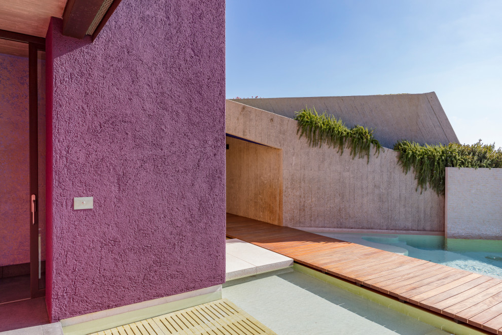 Immagine della villa ampia multicolore moderna a un piano con rivestimento in cemento e abbinamento di colori