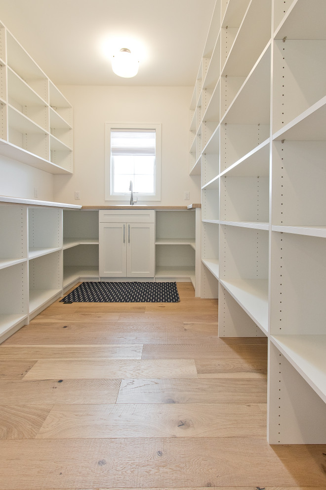 Inspiration for a large transitional u-shaped light wood floor and brown floor kitchen pantry remodel with flat-panel cabinets, white cabinets and white backsplash