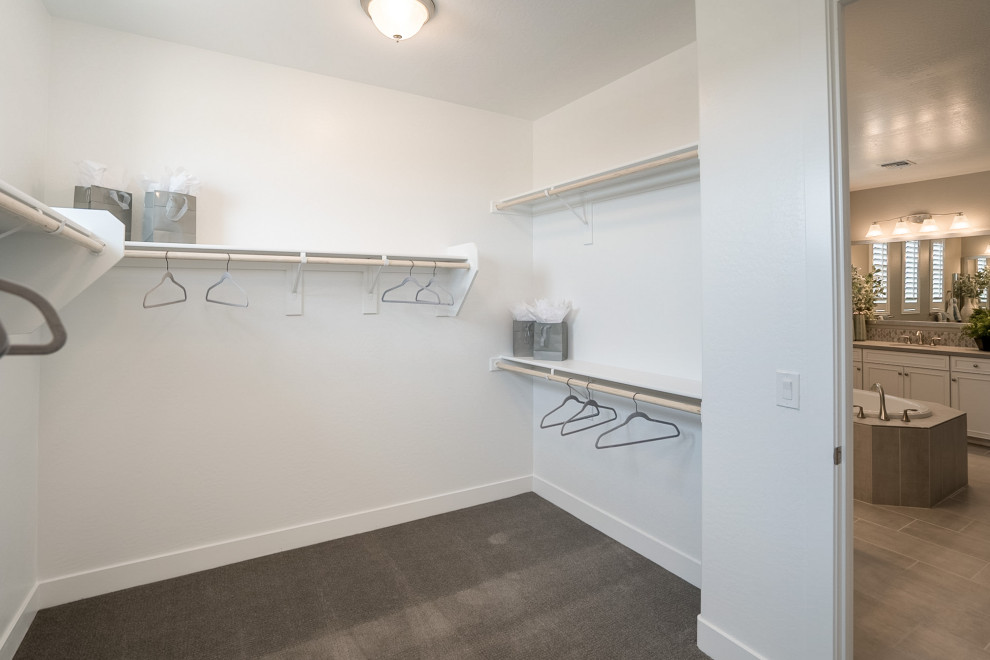 This is an example of a mid-sized contemporary walk-in wardrobe in Phoenix with carpet and grey floor.