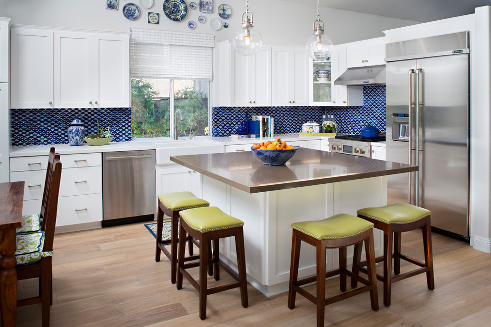 Photo of a transitional l-shaped kitchen in San Diego with white cabinets, blue splashback and with island.