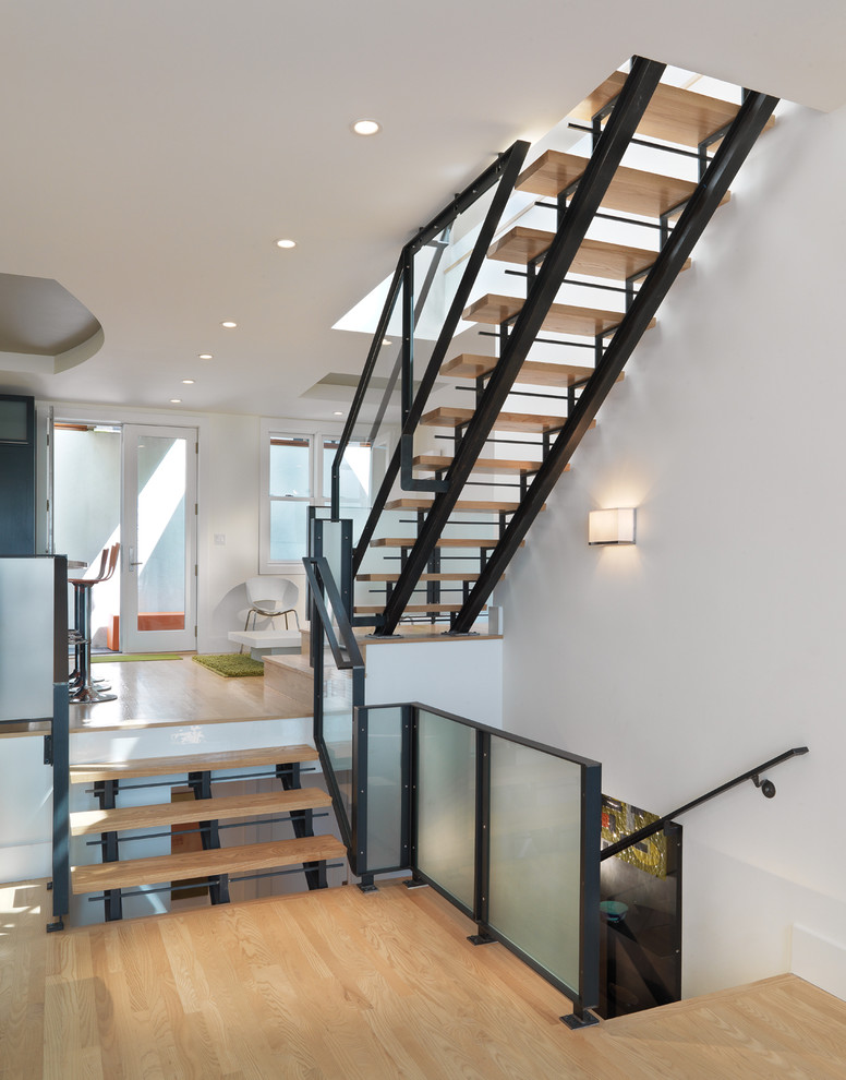 Design ideas for a scandinavian wood staircase in San Francisco with open risers and glass railing.