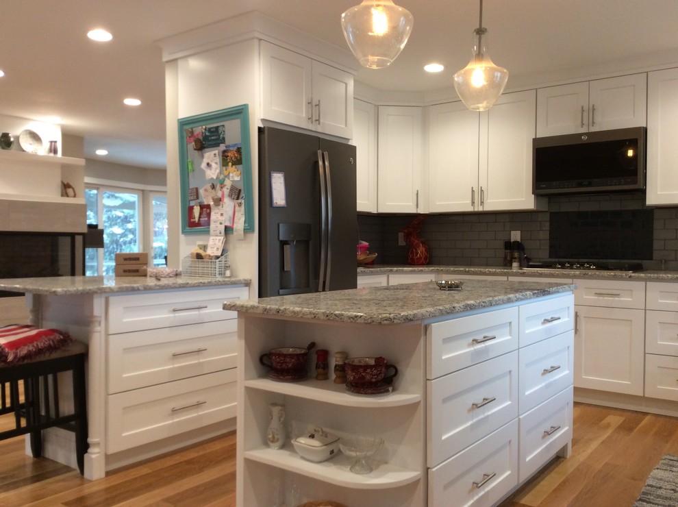 Inspiration for a mid-sized transitional u-shaped open plan kitchen in Salt Lake City with an undermount sink, shaker cabinets, white cabinets, granite benchtops, grey splashback, subway tile splashback, stainless steel appliances, light hardwood floors, with island and beige floor.