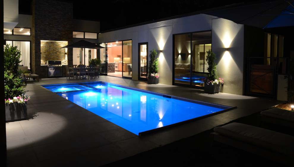 This is an example of a large modern backyard rectangular natural pool in Atlanta with a hot tub and tile.