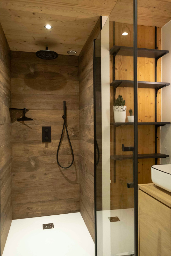 Bild på ett litet rustikt brun brunt badrum med dusch, med en kantlös dusch, brun kakel, vita väggar, cementgolv, ett konsol handfat, träbänkskiva, vitt golv och dusch med gångjärnsdörr