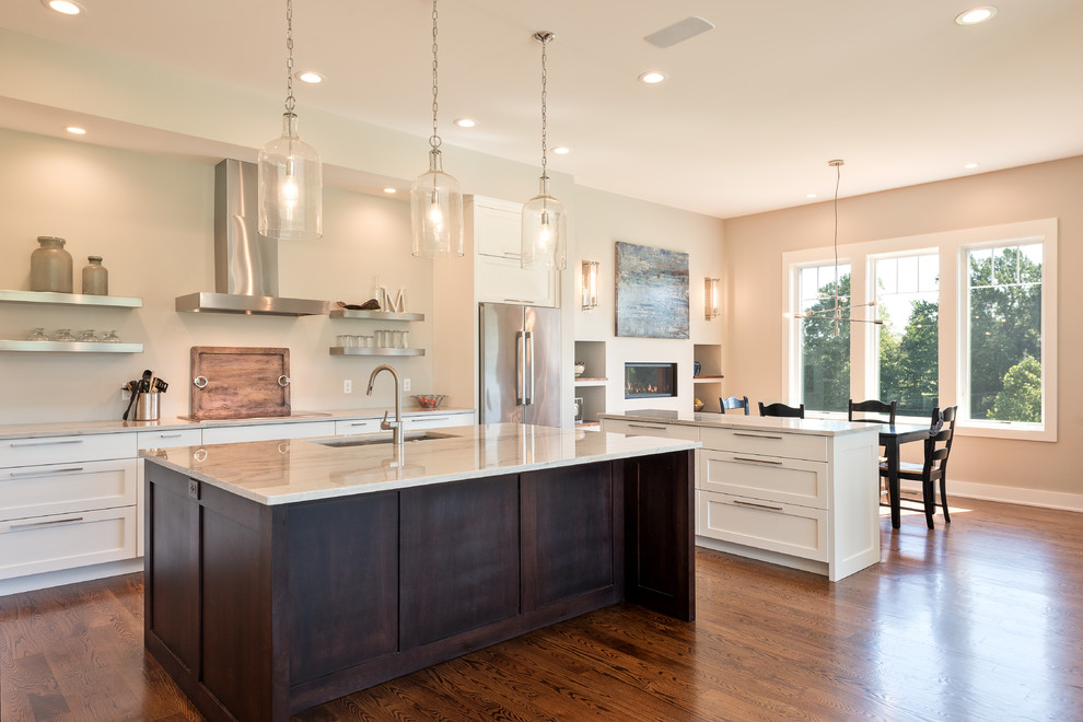 Inspiration for a mid-sized transitional u-shaped dark wood floor and brown floor open concept kitchen remodel with an undermount sink, shaker cabinets, white cabinets, marble countertops, stainless steel appliances and an island