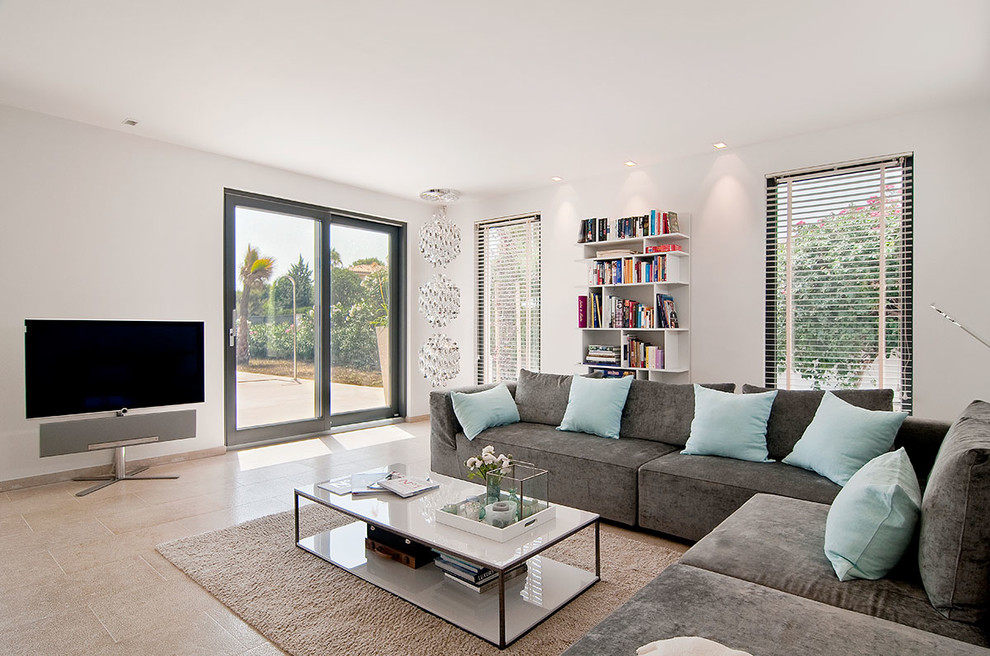 Inspiration for a large mediterranean open concept living room in Palma de Mallorca with a library, white walls, no fireplace and a concealed tv.