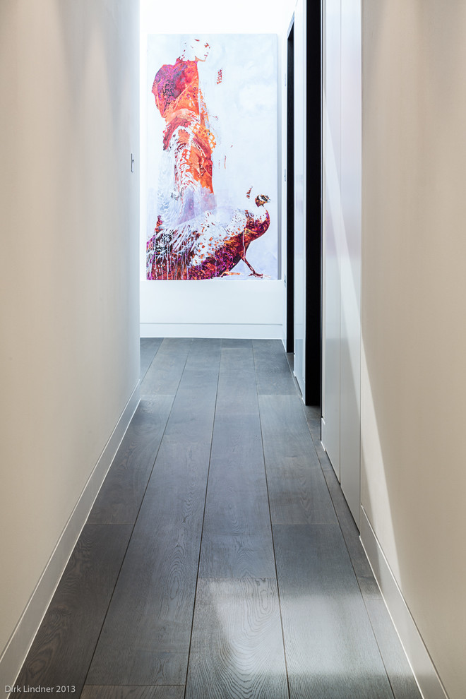 Photo of a contemporary hallway in London with white walls and dark hardwood floors.