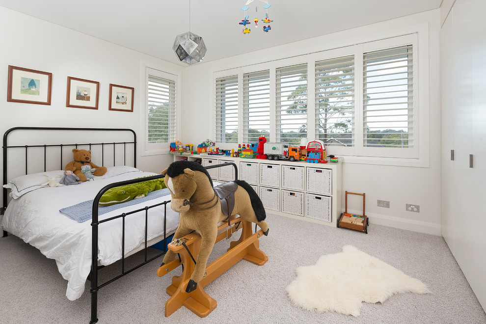 This is an example of a large transitional gender-neutral kids' bedroom for kids 4-10 years old in Sydney with white walls and carpet.