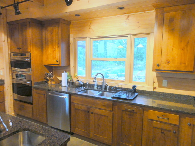 Inspiration for a rustic ceramic tile kitchen remodel with shaker cabinets, light wood cabinets, wood countertops and an island