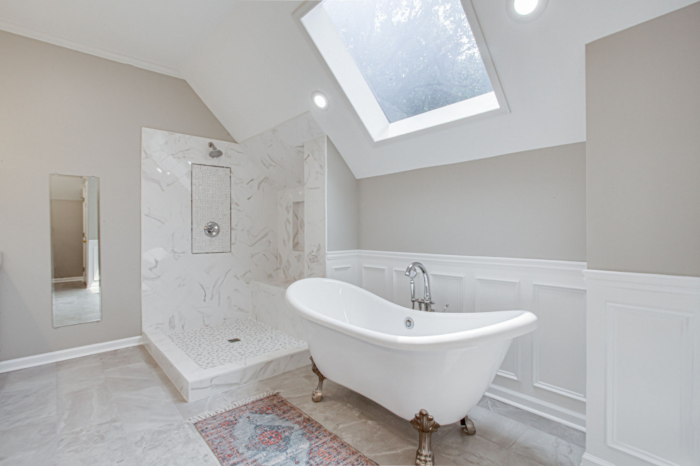 This is an example of a mid-sized transitional master bathroom in Atlanta with shaker cabinets, white cabinets, a claw-foot tub, an open shower, a one-piece toilet, gray tile, porcelain tile, grey walls, porcelain floors, an undermount sink, engineered quartz benchtops, grey floor, an open shower, grey benchtops, a shower seat, a double vanity, a built-in vanity, vaulted and decorative wall panelling.