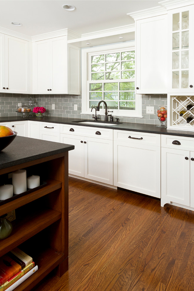 Design ideas for a traditional l-shaped eat-in kitchen in Minneapolis with an undermount sink, shaker cabinets, white cabinets, granite benchtops, blue splashback, subway tile splashback and white appliances.