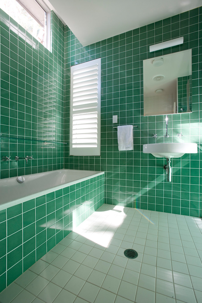 This is an example of a mid-sized transitional master bathroom in Central Coast with glass-front cabinets, an alcove tub, green tile, ceramic tile, ceramic floors, a pedestal sink and white floor.