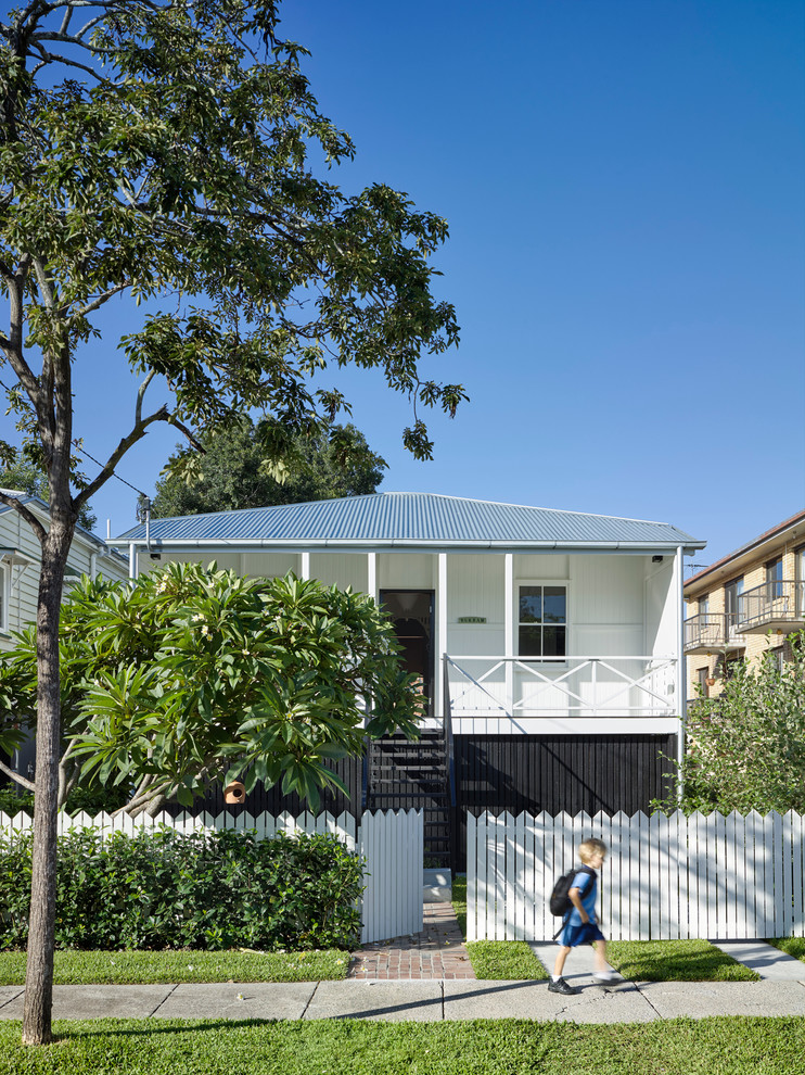 Photo of a transitional one-storey white exterior in Brisbane with wood siding and a hip roof.