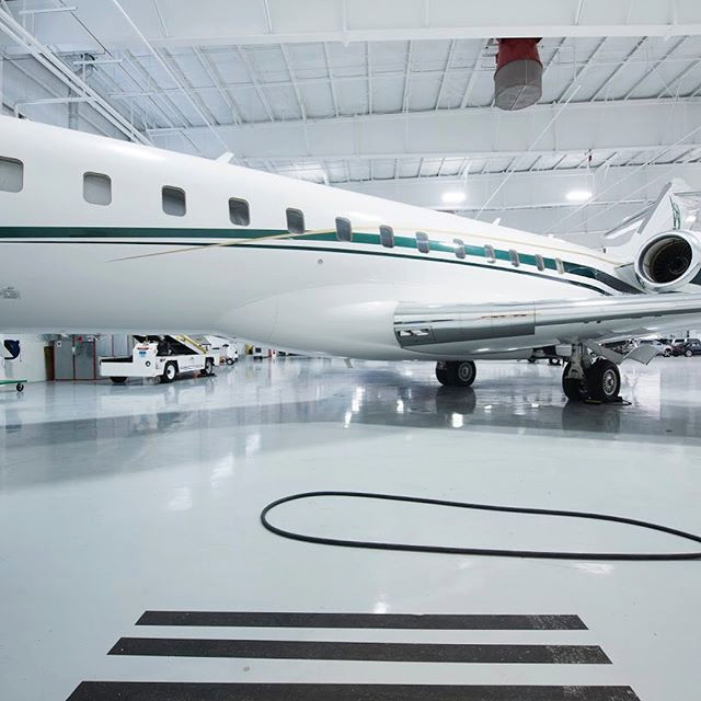 Luxury aircraft hangar interior with private jet at Rectrix Aero in Bedford, MA by Cabanilla Design Collective.