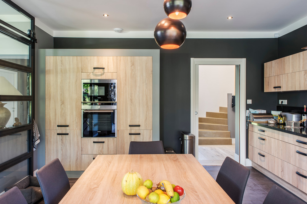 Inspiration for a large contemporary single-wall eat-in kitchen in Le Havre with light wood cabinets, stainless steel appliances, ceramic floors, no island and flat-panel cabinets.