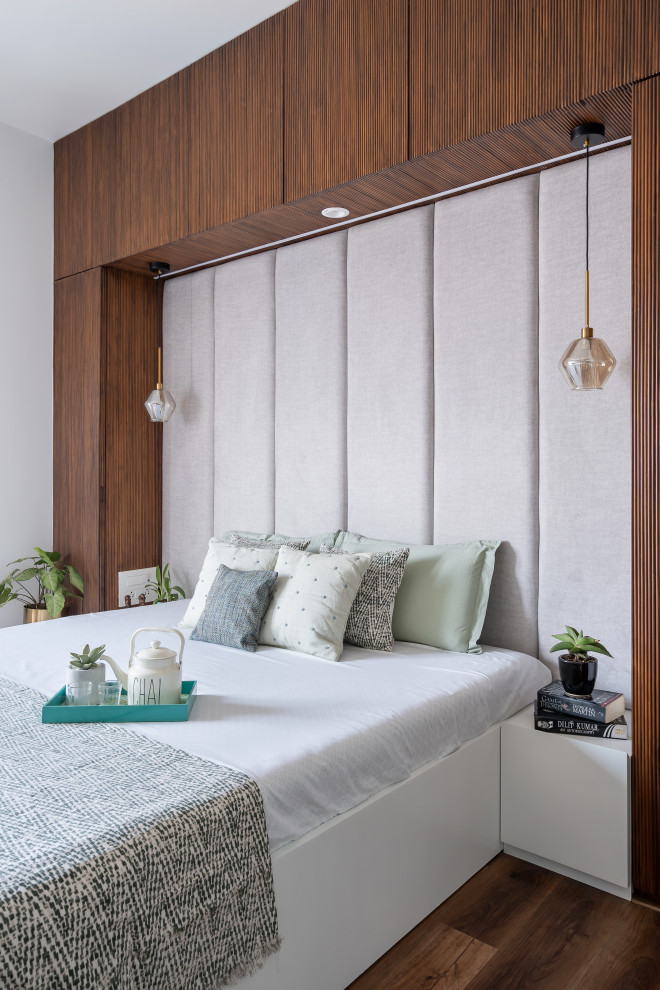 Foto di una camera da letto contemporanea con pareti bianche, parquet scuro e pavimento marrone