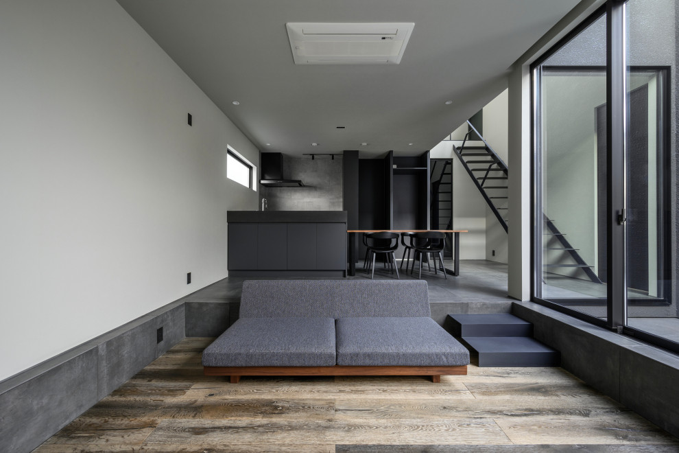На фото: открытая гостиная комната среднего размера в современном стиле с музыкальной комнатой, серыми стенами, полом из керамической плитки, телевизором на стене, серым полом, потолком с обоями и обоями на стенах без камина с
