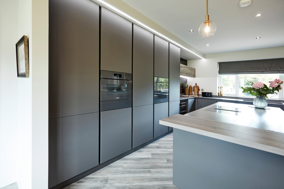 Design ideas for a mid-sized contemporary u-shaped eat-in kitchen in Other with an undermount sink, flat-panel cabinets, grey cabinets, quartzite benchtops, multi-coloured splashback, mirror splashback, coloured appliances, laminate floors, with island, beige floor and grey benchtop.