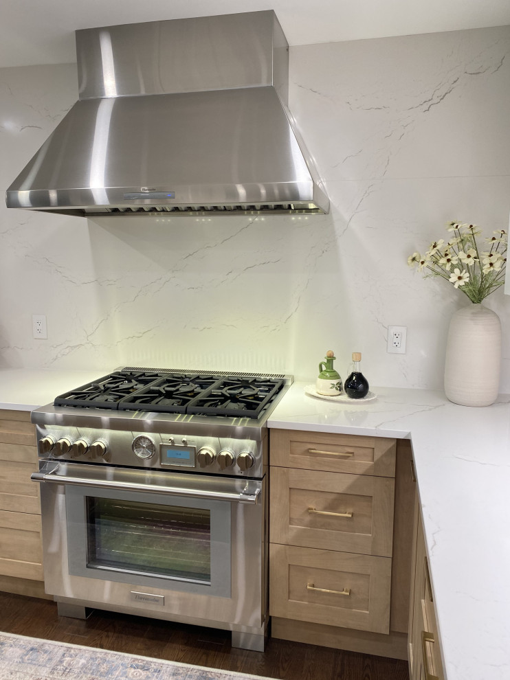 Eat-in kitchen - mid-sized transitional l-shaped medium tone wood floor and brown floor eat-in kitchen idea in Toronto with an undermount sink, shaker cabinets, white cabinets, quartz countertops, white backsplash, quartz backsplash, stainless steel appliances, an island and white countertops