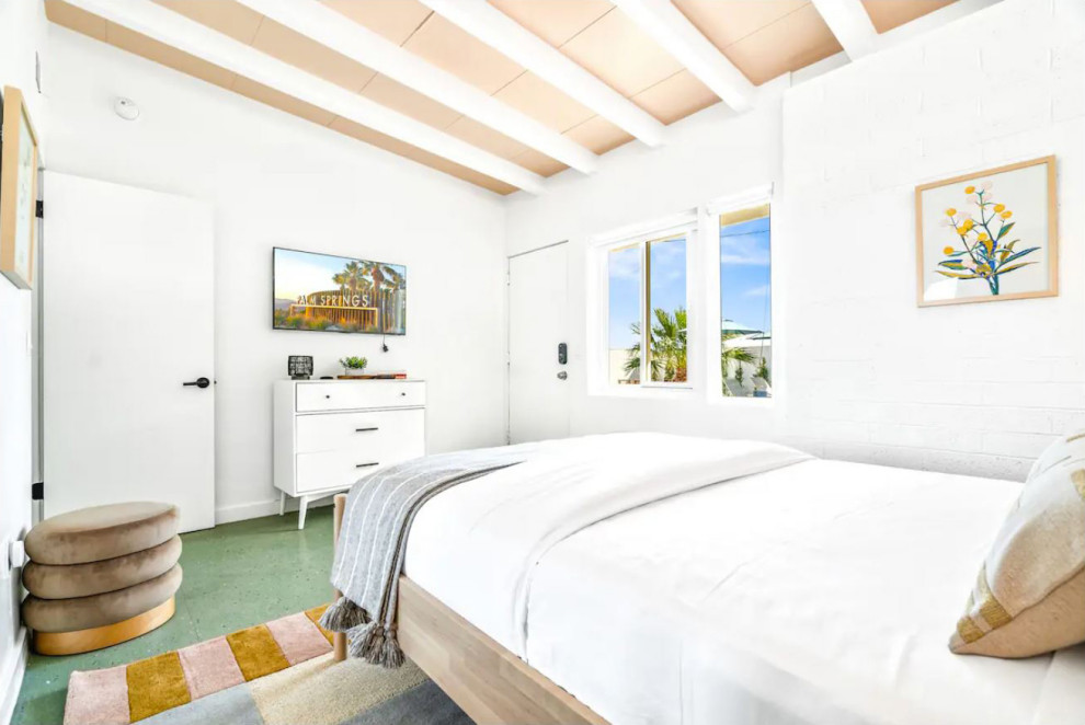 他の地域にあるミッドセンチュリースタイルのおしゃれな客用寝室 (白い壁、ラミネートの床、緑の床、表し梁、レンガ壁)