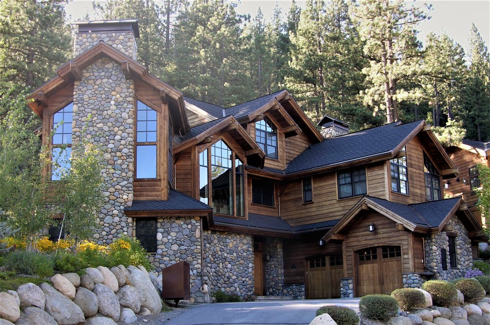 Expansive country three-storey brown exterior in Sacramento with stone veneer and a hip roof.