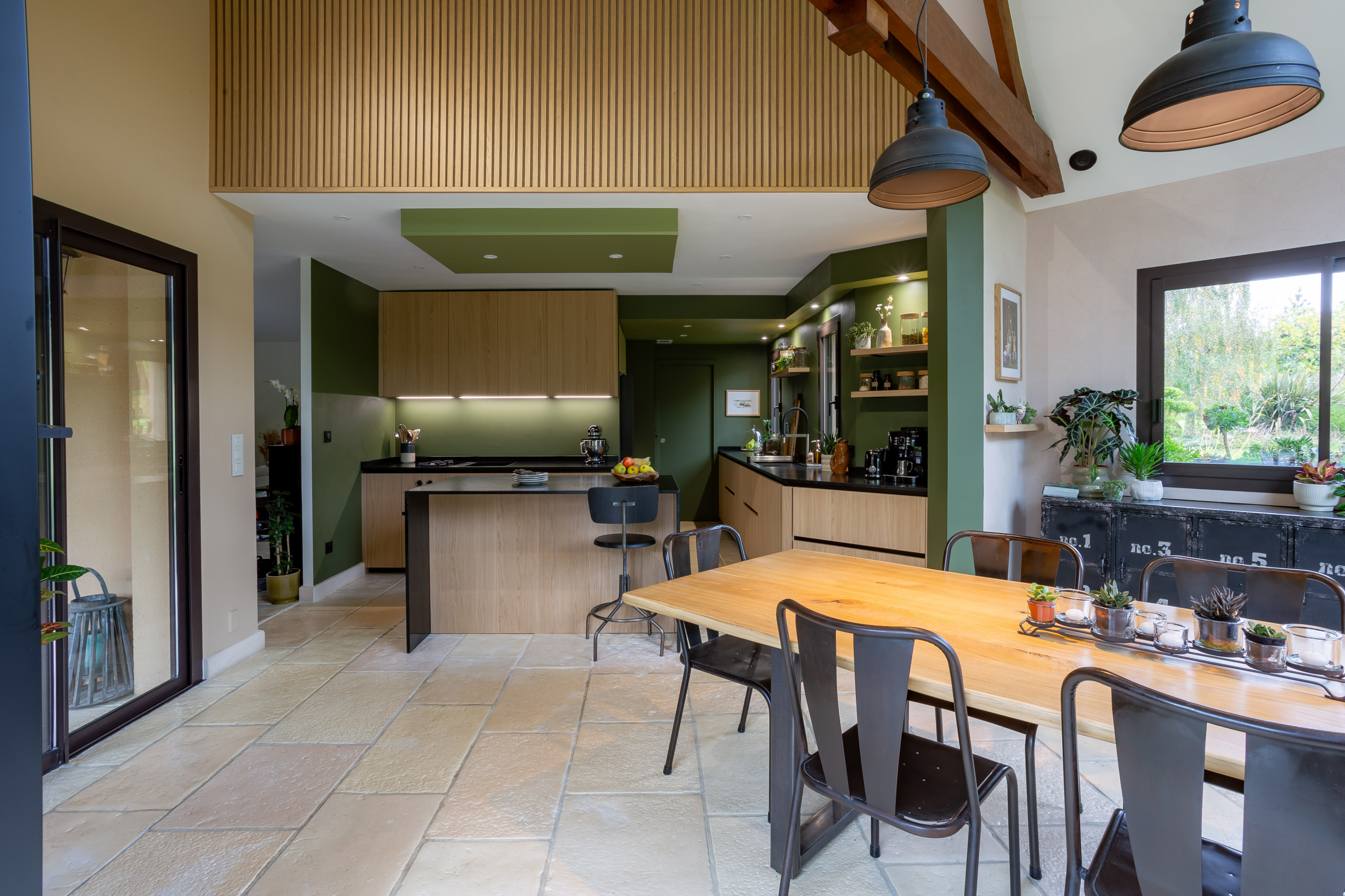 Réalisation d'une cuisine noire et bois dans un écrin végétal