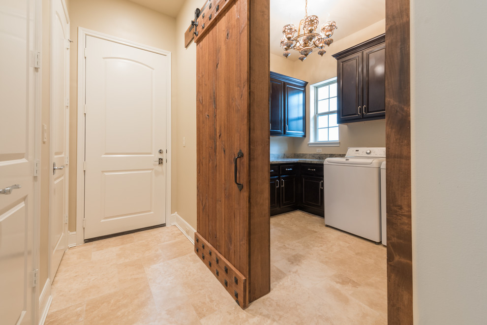 Large transitional l-shaped dedicated laundry room in Houston with raised-panel cabinets, dark wood cabinets, granite benchtops, beige walls, porcelain floors, a side-by-side washer and dryer, beige floor and multi-coloured benchtop.