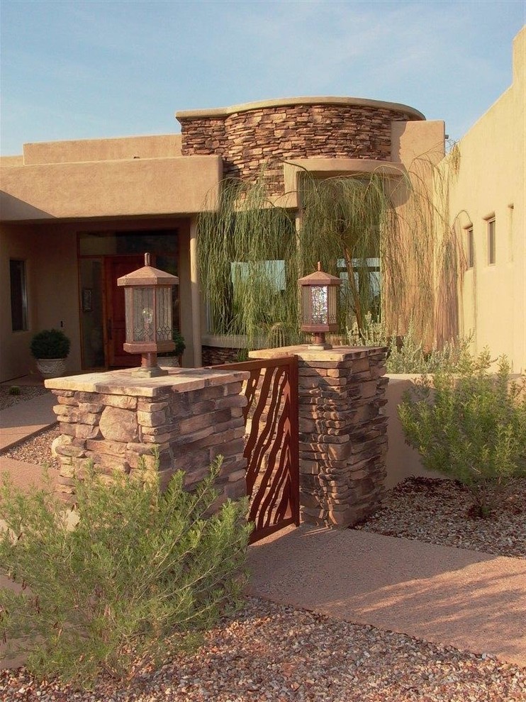 Mid-sized tuscan concrete floor and gray floor front door photo in Phoenix with brown walls and a medium wood front door