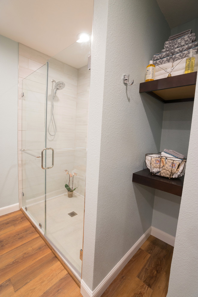 Photo of a large transitional master bathroom in San Francisco with shaker cabinets, dark wood cabinets, a freestanding tub, an alcove shower, a bidet, white tile, porcelain tile, blue walls, vinyl floors, an undermount sink, marble benchtops, brown floor and a hinged shower door.