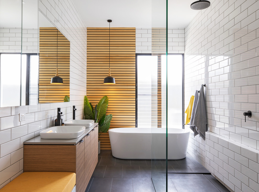 Inspiration for a mid-sized contemporary master bathroom in Adelaide with flat-panel cabinets, light wood cabinets, a freestanding tub, an open shower, white tile, subway tile, white walls, a vessel sink, grey floor and an open shower.