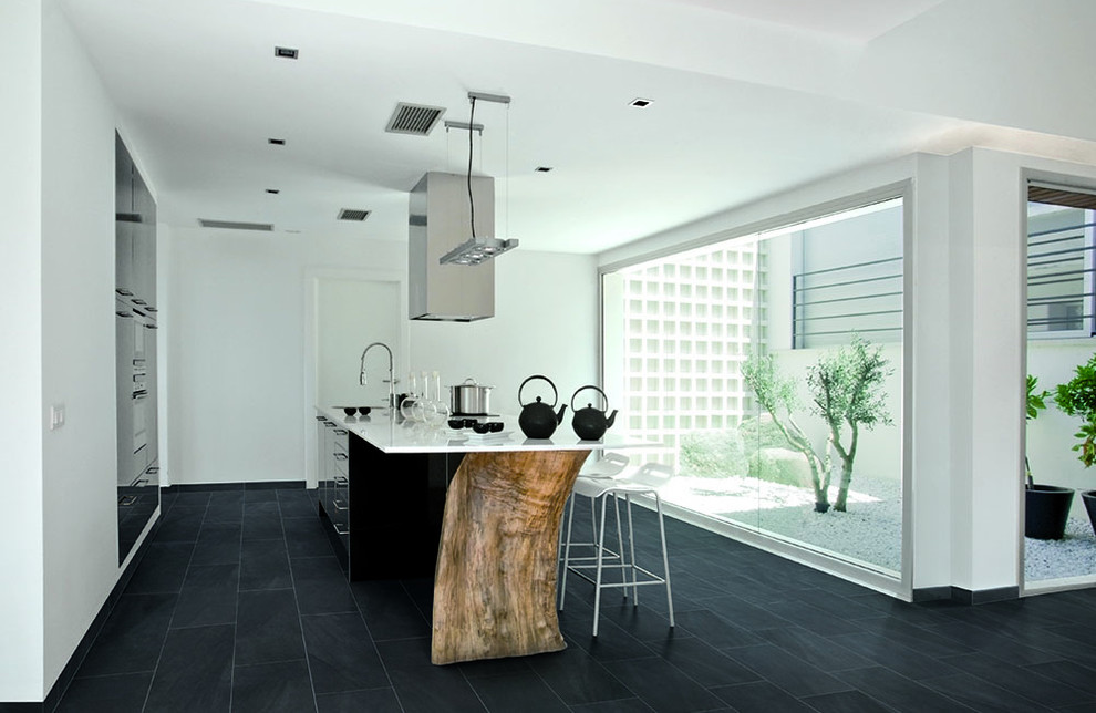 Design ideas for an asian kitchen in Miami with an undermount sink, solid surface benchtops, porcelain floors, with island and black floor.